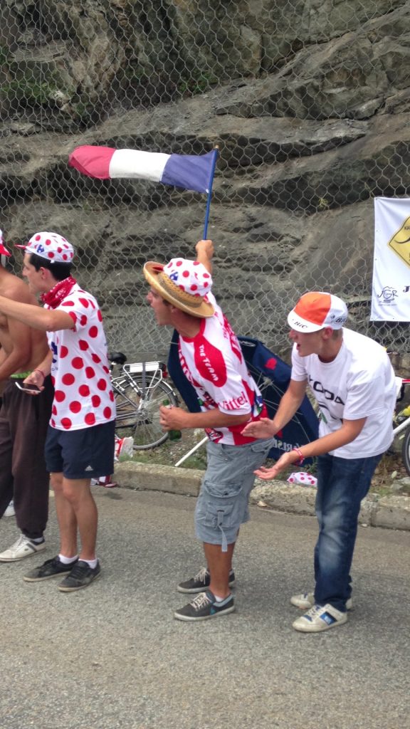 Tour de france fans cheering riders on the side of the road