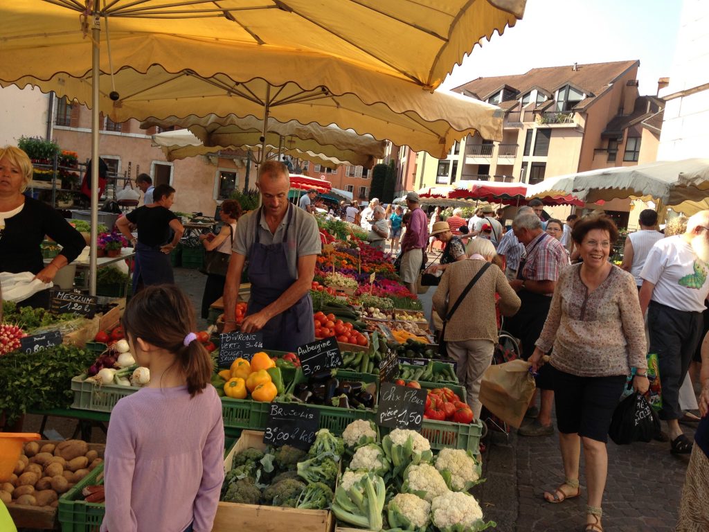 Shoppers at a produce stall at the Annecy French food market