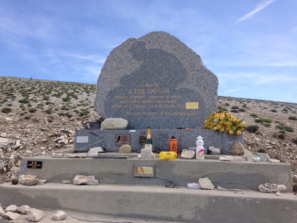 The Tom Simpson memorial on Mont Ventoux adorned with bidons and trinkets from cyclists