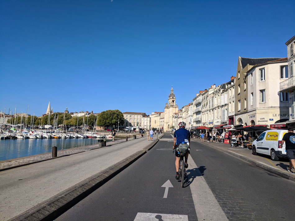 Cyclist riding by the port in La Rochelle France