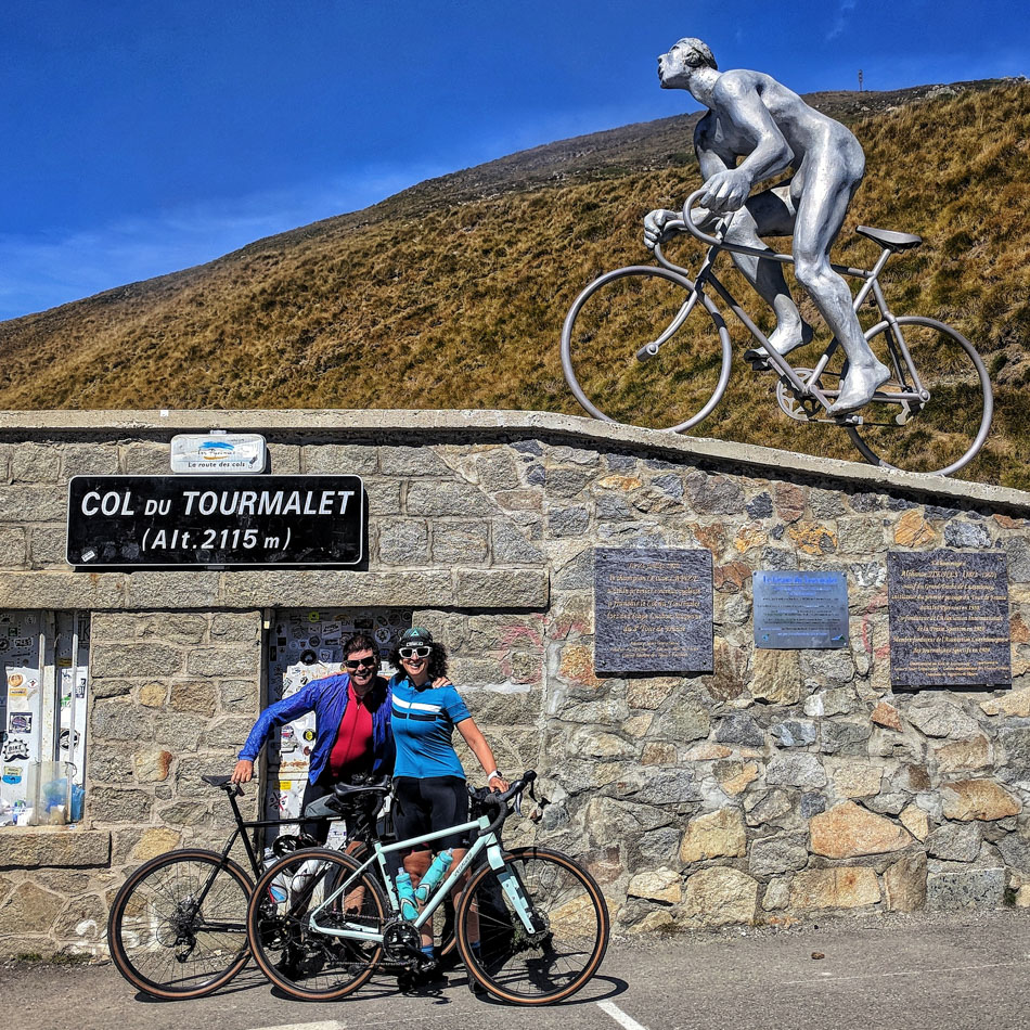Two cyclists at the top of the Col du Tourmalet in the Pyrenees