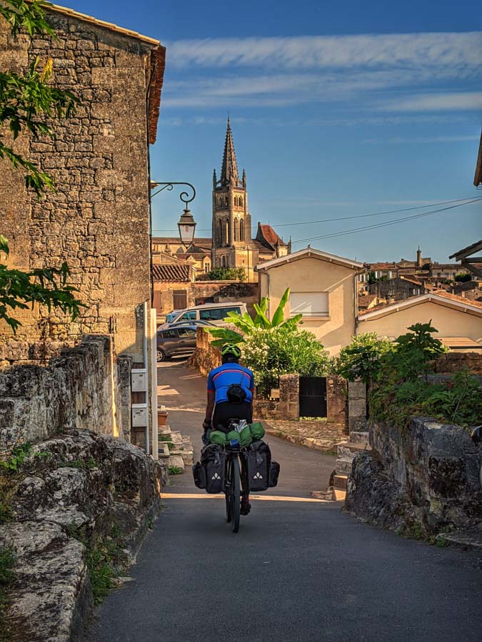 Cyclist on a cycle tour riding through the village of Saint-Èmilion, France