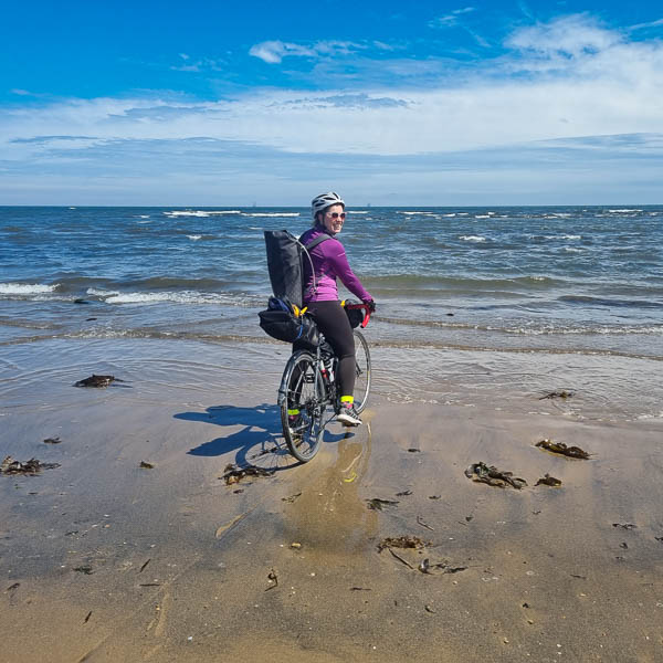 Viivi Rissanen dipping her bike in the ocean New Zealand