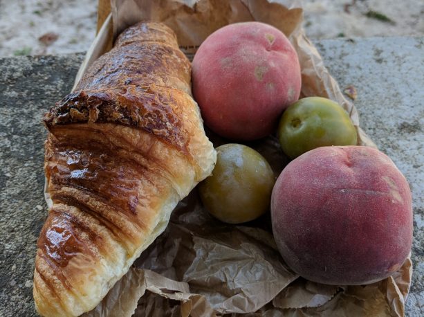 A croissant and fruit purchased from the French market food