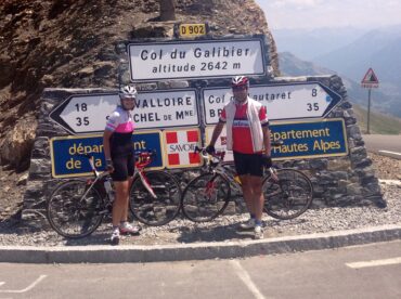 cyclists on a ride in the French Alps in front of col du galibier