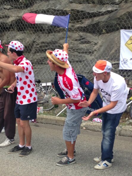 Tour de france fans cheering riders on the side of the road
