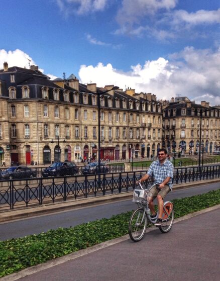 A man cycling in Bordeaux on a hire bike